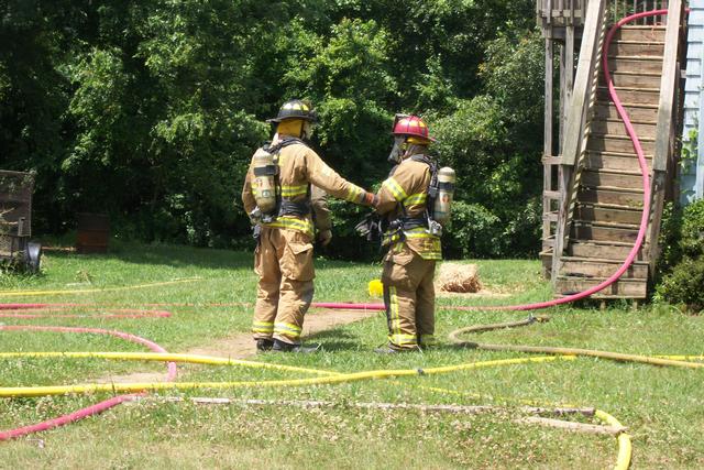 Wayside VFD Lt. Eli Moore (R) and another firefighter prepare to re-enter structure